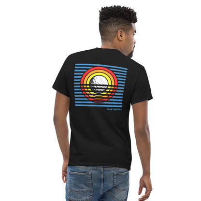Male model wearing a Black Sun Up golf streetwear casual everyday t-shirt.  Bold colourful graphic sunrise design featuring a golf ball as the sun with yellow, orange and red rings and striking blue lines. Casual everyday golf streetwear by fourteefore